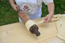 Wrapping the flat dough strip around the spit — image 2