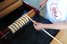 Wrapping the spun dough strip around the spit — image 1